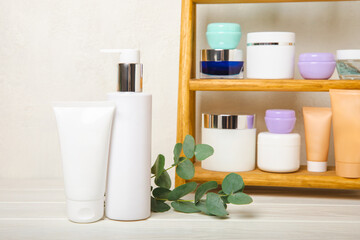 Cosmetics for face, body and hair care on a wooden shelf in the bathroom. A set of cosmetics, shampoo, cream, serum and scrub on a shelf in the bathroom. Foreground. copy space. Beauty concept.