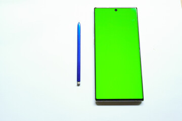 Smartphone mockup with green screen, stylus pen on the side, top view, isolated on white background