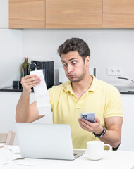 Close up of unhappy man sitting at the table, stressed and confused by calculate expense from...