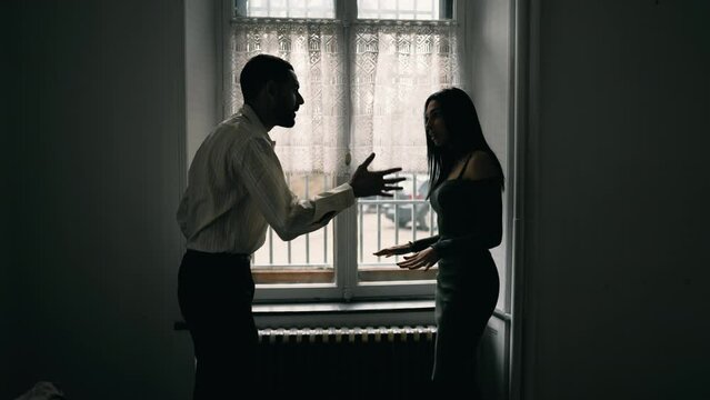 Angry man shouting at woman. Dramatic scene of couple yelling at each other in dispute. People quarreling during crisis, pointing fingers and blaming the other