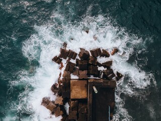 Drone view of waves crashing at Seixal Pier in Madeira, Portugal