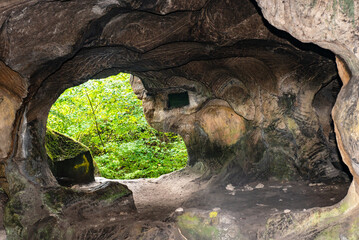 Huel Lee or Hohllay on the Mullerthal trail in Luxembourg, open cave with view to the forest, sandstone rock formation

