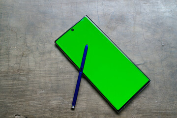 Smartphone mockup with green screen, stylus pen on the side, top view