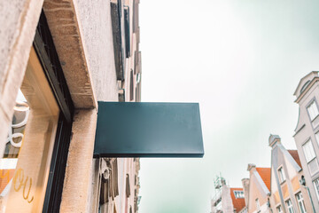 Black square signboard on the marble wall of a modern business center, mock up