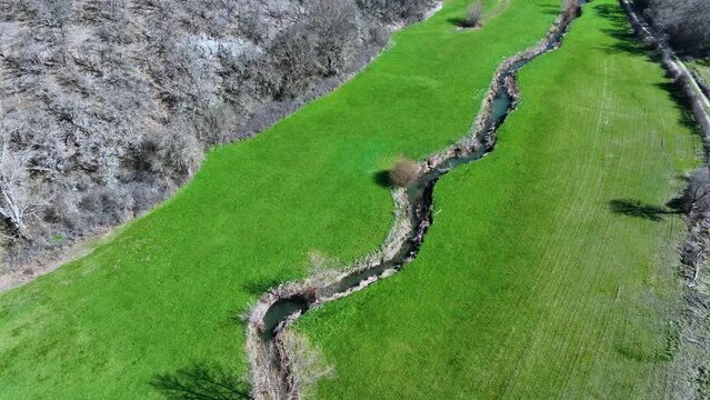 Meanders in the Lucio River in Renedo de la Inera. Aerial view from a drone. Recuevas Valley. World geological heritage UNESCO. Las Loras Geopark. Palencia. Castile and Leon. Spain, Europe
