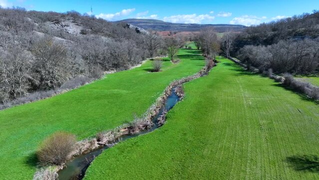 Meanders in the Lucio River in Renedo de la Inera. Aerial view from a drone. Recuevas Valley. World geological heritage UNESCO. Las Loras Geopark. Palencia. Castile and Leon. Spain, Europe