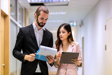 Diverse friend  partners colleagues talking walking in modern office hallway. Confident business partners walking down in office building and talking. Professional business people walking and talking