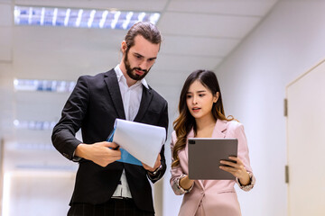 Diverse friend  partners colleagues talking walking in modern office hallway. Confident business partners walking down in office building and talking. Professional business people walking and talking