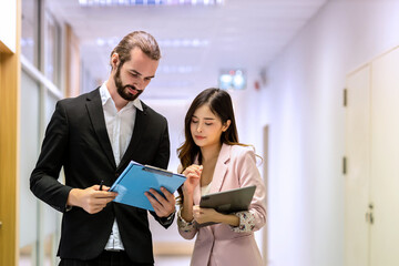 Diverse friend  partners colleagues talking walking in modern office hallway. Confident business partners walking down in office building and talking. Professional business people walking and talking