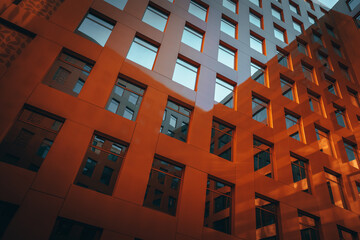 The brown facade of a stylish business building with modern architecture with a grid pattern...