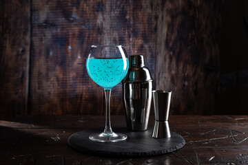 Bright blue cocktail in a glass. Nice drink presentation. Bartender set and drink.
