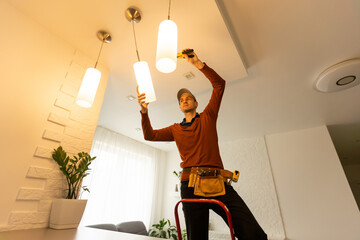 Electrician man working on exterior light, install LED replacement lamp at home. Maintenance concept.