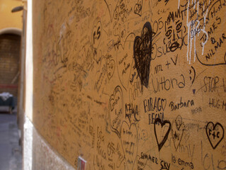 Scribbled hearts and initials on house wall in Verona, Italy
