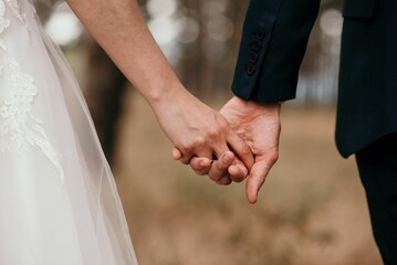 Couple holding each others' hands during the wedding ceremony suit