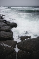 Vertical shot of water crashing on rocks in Newfoundland