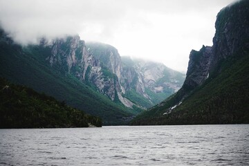 Beautiful shot of cliffs in Western Brook Pond with fog
