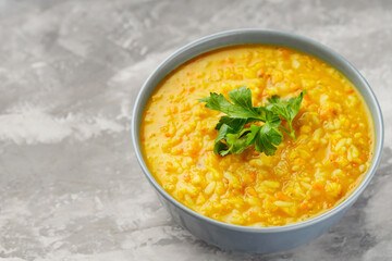 Bowl of lentil soup on concrete. Red lentil soup with fresh parsley. Traditional turkish or arabic dish. Copy space. Top view