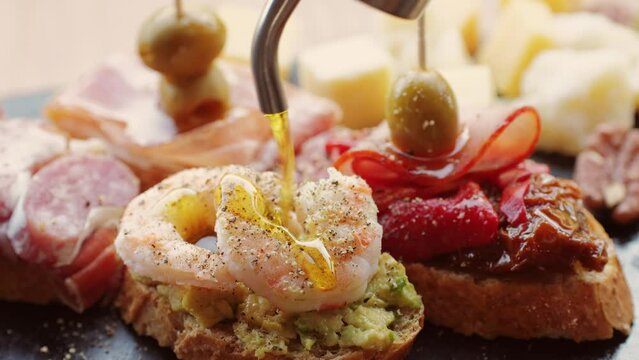 Italian or Spanish restaurant with traditional tapas food, Spanish cuisine, delicious tapas and cheese plate, bruschetta with cheese, olives dry tomatoes and tasty sandwich bar appetizer, buffet