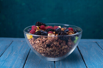 Large bowl with granola and berries. Homemade berries and chocolate granola. Front view.