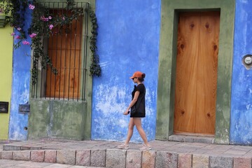 Obraz na płótnie Canvas Girl walking in colorful city in Mexico
