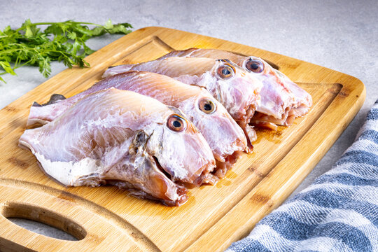 Fish "peroa" clean on the wooden board and coriander, ready to fry. Traditional Brazilian beach food known as: "Peixe Frito Capixaba"