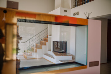 View through an empty aquarium to the fireplace, interior of the house