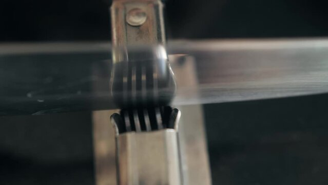 Man Sharpening the knife with a whetstone on a wooden background close up.