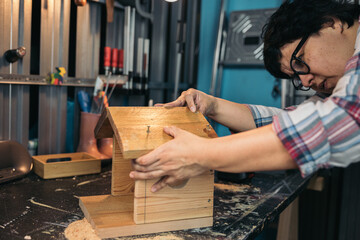 Woman building a small wooden birdhouse