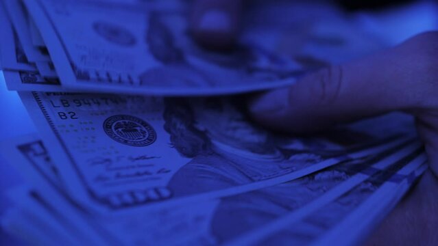 Counting American 100 dollar banknotes. Businesswoman counts the bills of money, rich woman shifting a stack of 100 US dollars by hands.