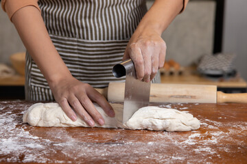 Baker Hand Cutting Raw Dough with a Knife