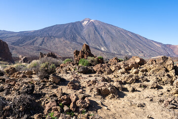 un désert rocailleux avec un volcan en arrière plan