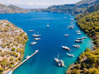 Aerial drone photo of Binlik Bay, located in the midst of Göcek and Dalaman, Fethiye. Daily tour boats and private yachts anchor to have serenity and enjoy the secluded bay. - obrazy, fototapety, plakaty