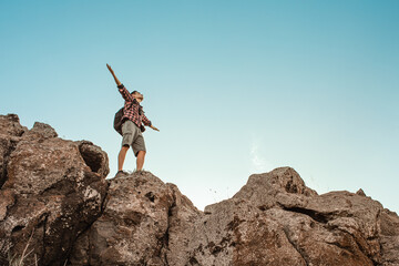 Hiker with arms up standing on the top of the mountain - Successful man enjoying triumph - Sport and success concept	