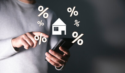 man holds a house and a percent sign
