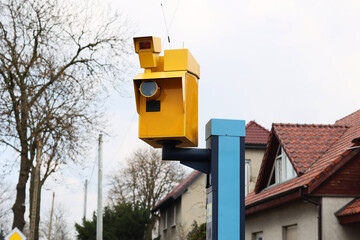 Żółty fotoradar robi zdjęcia wykroczeń drogowych kierowcom samochodów.  - obrazy, fototapety, plakaty