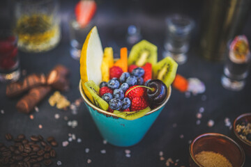 Vibrant fruit salad, dark background, blurred decorations, healthy and delicious, colorful, appetizing presentation