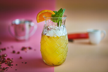 Tropical Bliss: Pineapple cocktail, pineapple glass, juice and garnish, beige and pink background, colorful decorations, refreshing and vibrant