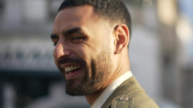 Portrait of a confident young middle eastern man smiling at camera in tracking shot motion close up face