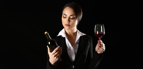 Portrait of elegant female sommelier on dark background