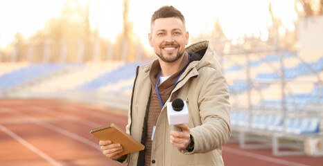 Male reporter with microphone at the stadium