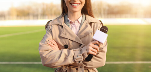 Female reporter with microphone at the stadium
