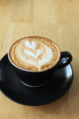 a cup of late coffee with flower shape design on top at cafe 