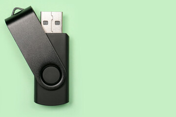 Black USB flash drive on green background
