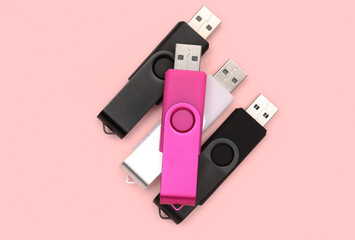 USB flash drives on pink background