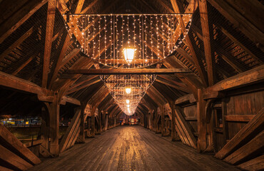 Illuminated by festive lighting, a stunning wooden bridge guides the way forward in Olten, Switzerland.
