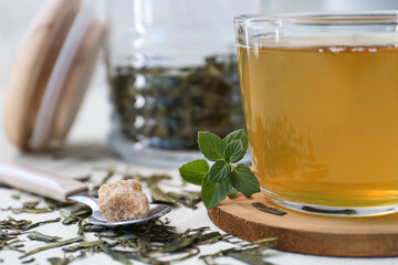 Cup of hot green tea on light background, closeup