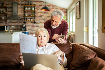 Senior couple going over their bills in a living room