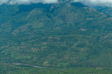 landscape of the green mountains of colombia over the fonce river canyon, in the background a small town