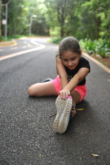 menina se alongando em parque, alongamento para exercicio na natureza 