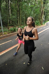 mulher e filha fazendo exercicios ao ar livre, treino em família 